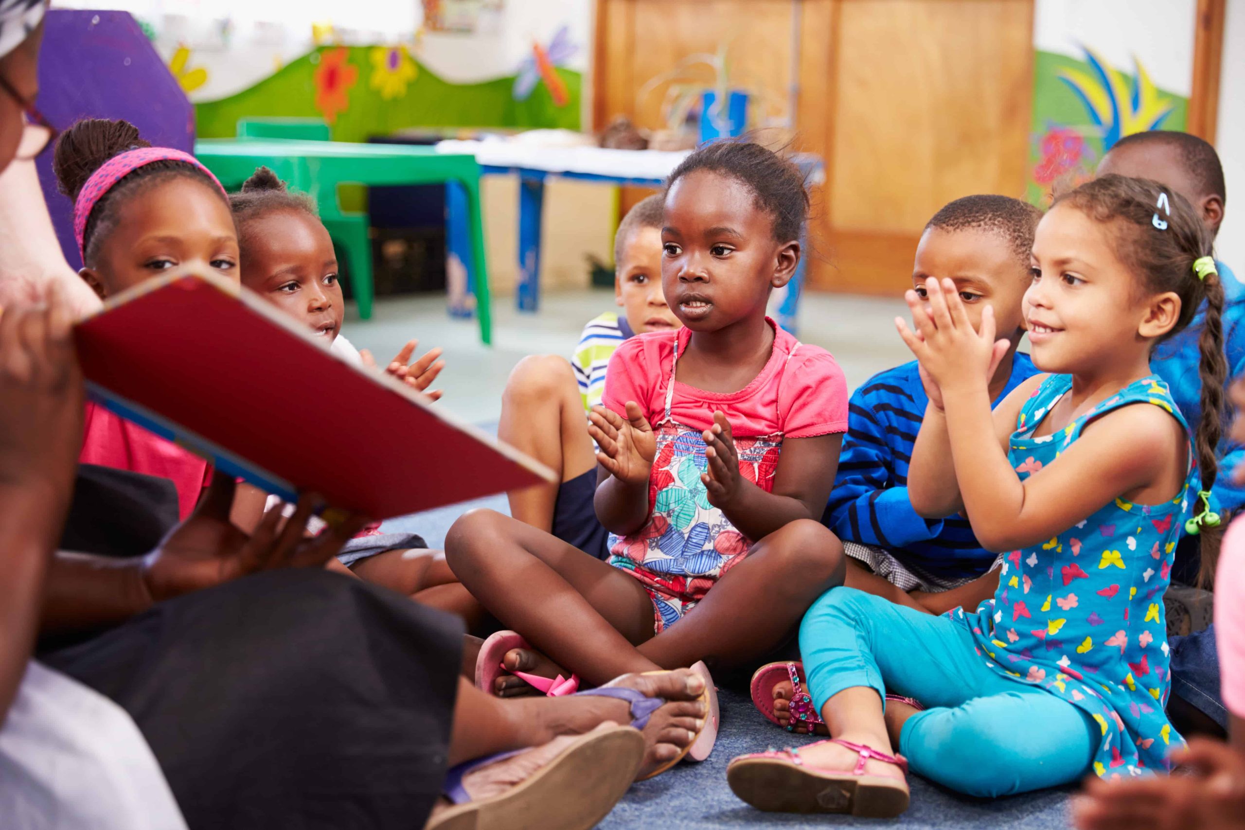 Group of kids clapping together in reading class