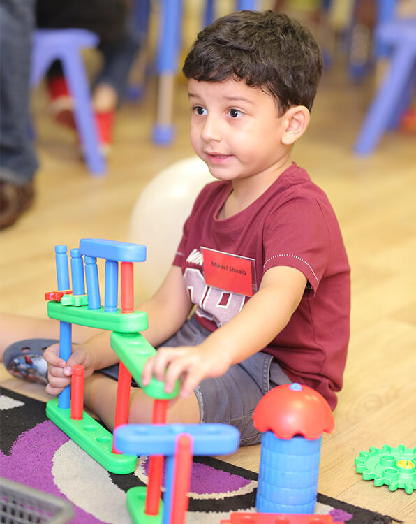 Little kid in Early learner programs for children building blocks