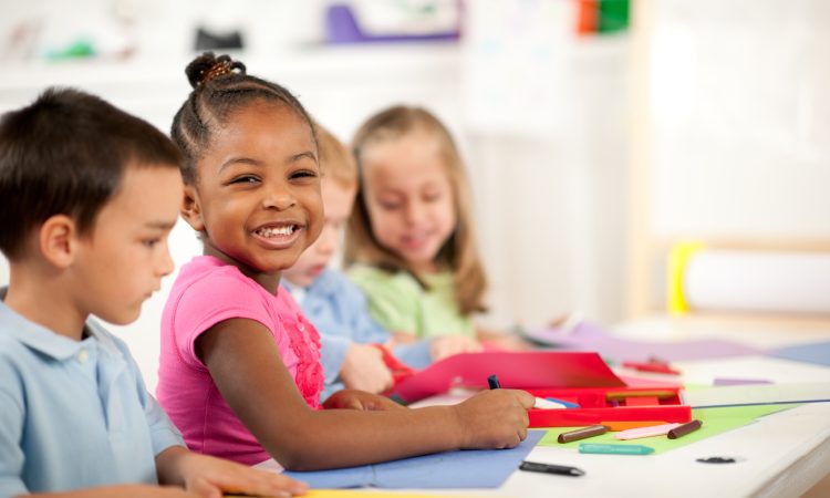 a cute girl doing coloring activity with wide smile